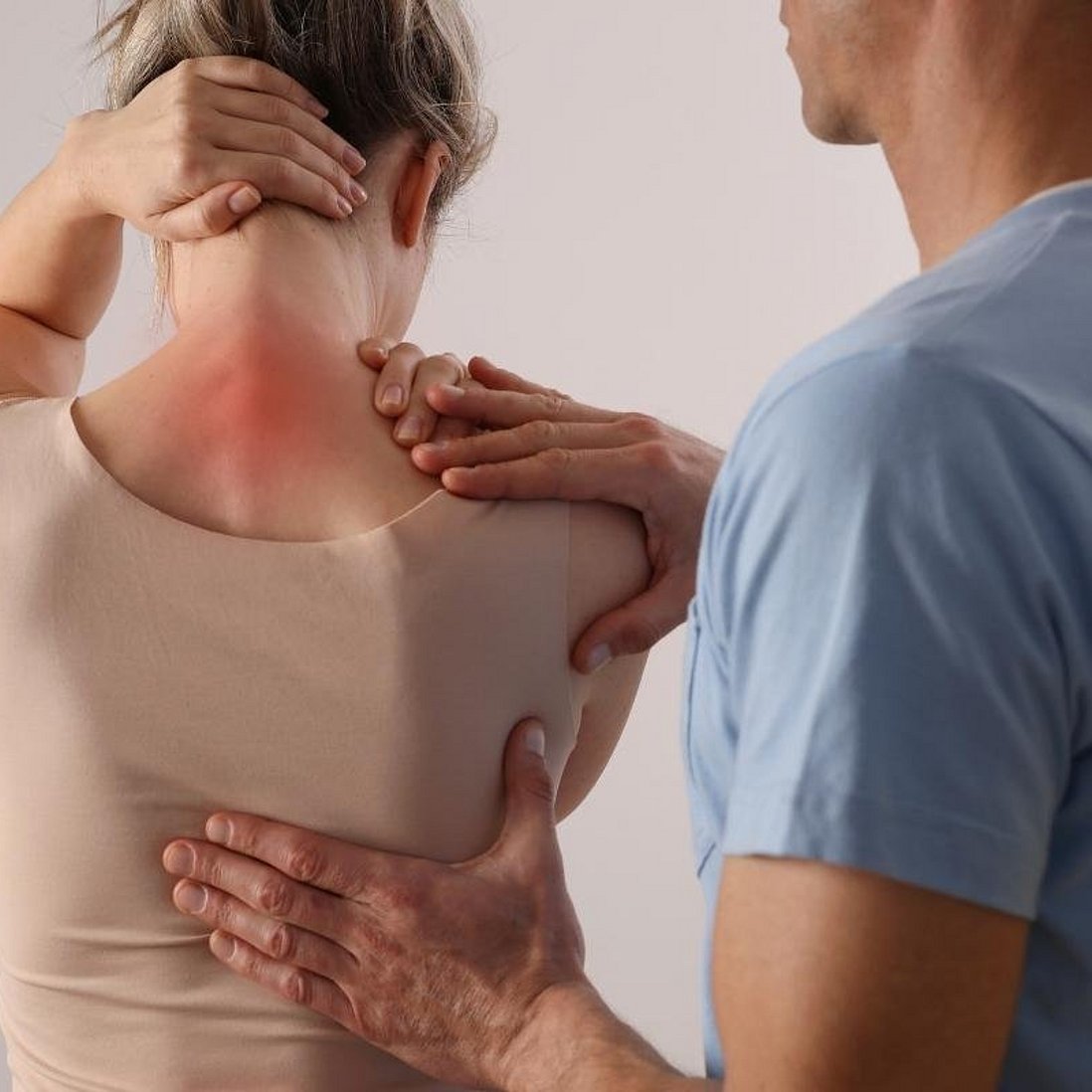 Frau mit Schmerzen im Nacken bei Therapeut
